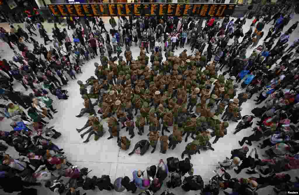 Aktor yang berkostum ala seragam serdadu dalam Perang Dunia I bergabung dalam sebuah kelompok di Stasiun Waterloo, untuk memperingati dimulainya Pertempuran Somme, di London, Inggris.