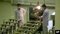 伊朗技术人员在生产铀燃料的设施前工作。（2009年4月9日）