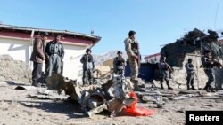 Afghan policemen stand guard at the site of an attack by insurgents against the Kabul traffic police headquarters in Kabul, Jan. 21, 2013.