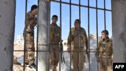 Fighters from the Kurdish People's Protection Units (YPG) monitor troop movements in the area of Afrin, along Syria's northern border with Turkey, on June 9, 2017.