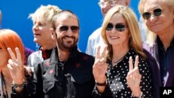 Ringo Starr, left, poses with his wife Barbara Bach, center, and guitarist Joe Walsh, right, during a 77th birthday celebration for Starr at Capitol Records, July 7, 2017, in Los Angeles.