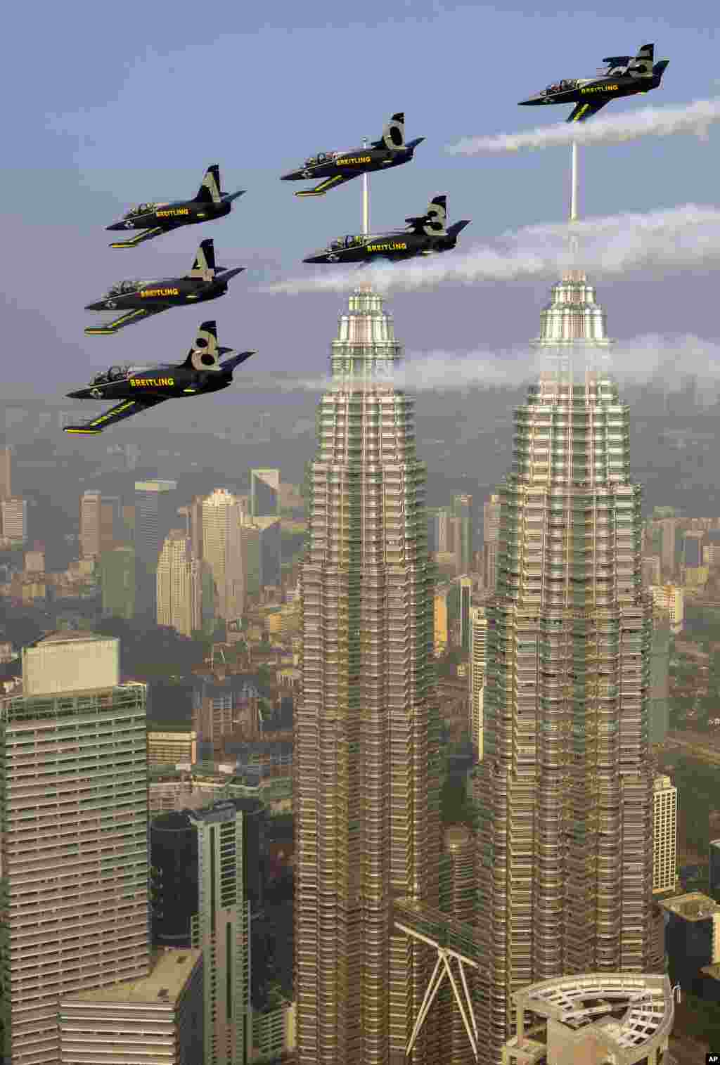 Tim Jet akrobatik Breitling terbang di atas Menara Petronas di atas Kuala Lumpur, Malaysia. Tim Jet akrobatik ini disponsori oleh perusahaan jam tangan mewah Swiss &#39;Breitling&#39;.