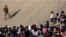 Members of the Texas National Guard stand guard on the banks of the Rio Bravo river, the border between the U.S. and Mexico