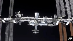 FILE - This image made from NASA TV shows the international space station, seen from the SpaceX Crew Dragon spacecraft, April 24, 2021. NASA earlier this week delayed a planned spacewalk due to menacing space junk. 