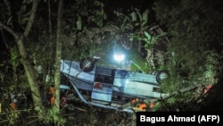 Tim penyelamat mengevakuasi korban kecelakaan bus yang jatuh ke jurang di Kecamatan Wado, di Sumedang, Jawa Barat, yang merenggut nyawa 27 orang, Rabu, 10 Maret 2021. (Foto: AFP/Bagus Ahmad)