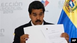 Nicolas Maduro holds official certificate declaring him winner of presidential election, Electoral Council, Caracas, April 15, 2013.