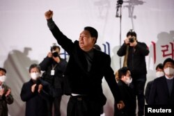 한국 제1야당 국민의힘 윤석열 대선 후보가 선거운동 마지막 날인 8일 서울 시내 유세에서 주먹을 들어 올리고 있다.