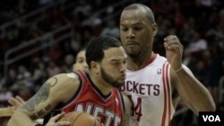 Deron Williams, kiri, berusaha melewati pemain Houston Rockets Chuck Hayes dalam pertandingan hari Sabtu (26/2) di Houston. Akhir pekan ini New Jersey Nets akan menghadapi Toronto Raptors di London.