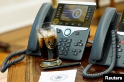 2018年12月11日白宫椭圆形办公室的电话和总统特朗普的一杯可口可乐。