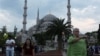 Des touristes prennent des photographies en face de la Mosquée bleue à Istanbul, Turquie, le 4 juin 2013.