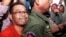 Hong Sok Hour, left, a senator from the opposition Cambodia National Rescue Party, is escorted by riot police officers, center, at Phnom Penh Municipal Court in Phnom Penh, Cambodia, Oct. 2, 2015. 