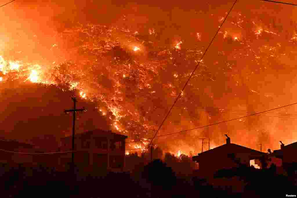 Flames rise as a wildfire burns next to the village of Ano Loutro, near Corinth, Greece, Sept. 29, 2024.