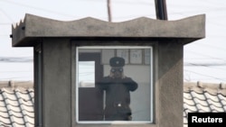 중국과 접경도시 북한 신의주 국경 초소에서 북한군 병사가 망원경으로 중국 쪽을 바라보고 있다. 압록강 너머 중국 단둥에서 촬영한 사진이다. (자료사진)