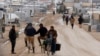 FILE - Syrian refugees travel on the main street of Al Zaatari refugee camp in the Jordanian city of Mafraq, near the border with Syria, Jan. 15, 2015.