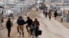 Syrian refugees travel on the main street of Al Zaatari refugee camp in the Jordanian city of Mafraq, near the border with Syria, Jan. 15, 2015.