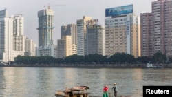 资料照：2013年12月7日，广东省广州市，一对夫妇沿着珠江(或珠江)附近的办公楼钓鱼。（路透社）