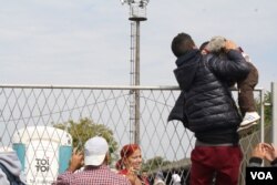 Authorities don’t try to stop small children from sneaking inside, but teenagers that scale the fence are told to climb back out, Opatovac, Croatia, Sept. 22, 2015. (Heather Murdock/VOA)
