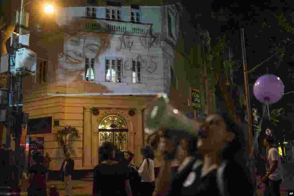 Foto Lucia Perez,16, yang diperkosa dan dibunuh di Argentina, diproyeksikan ke sebuah gedung saat para perempuan berdemonstrasi melawan kekerasan berbasis gender di Rio de Janeiro, Brazil (25/11). (AP/Leo Correa)