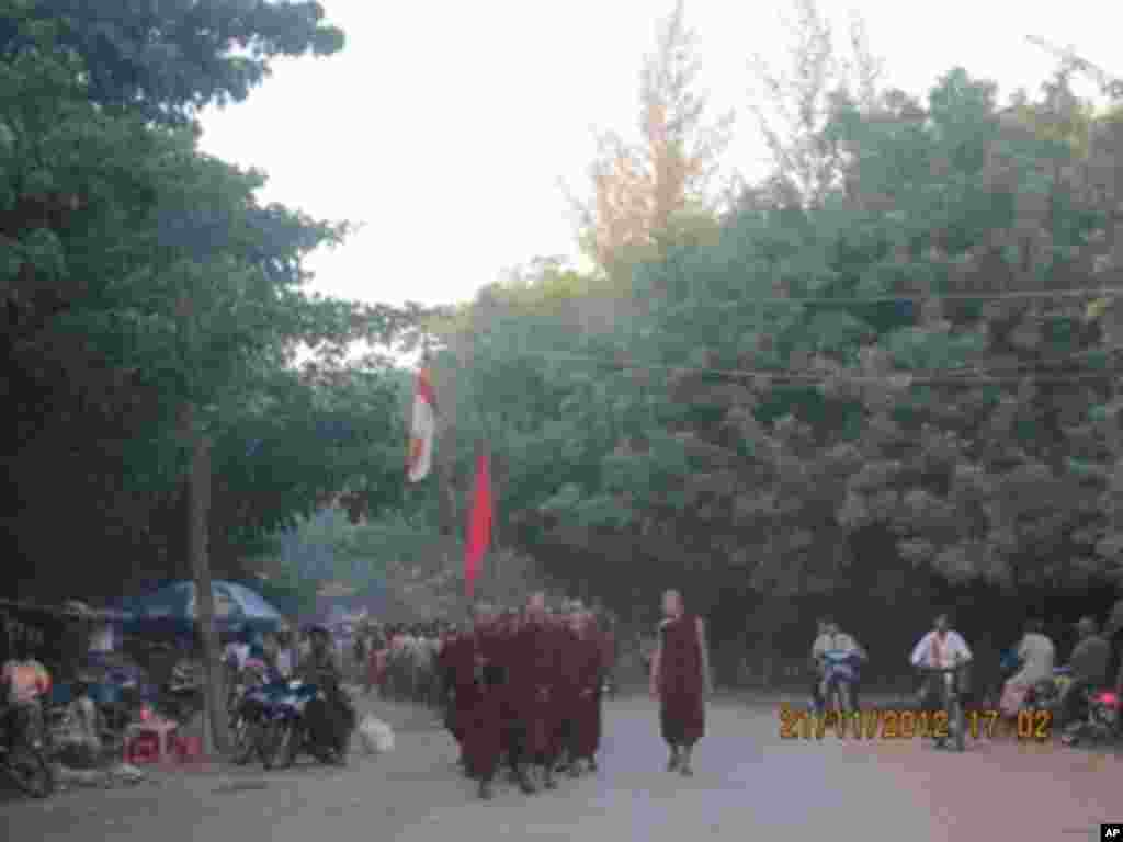 Petugas keamanan memegang bendera bertuliskan &quot;Berhenti!&quot; di gerbang yang menandai perbatasan antara kota Tamura dan Okuma di Okuma, prefektur Fukushima (1/4).
