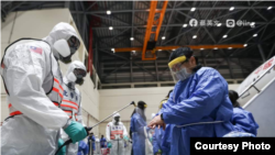 经由第二批武汉包机返回台湾的民众接受军队化学兵的检疫作业(蔡英文脸书)