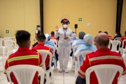 Health workers and fireman sit under observation after receiving doses of the Oxford-AstraZeneca coronavirus vaccine, in Guatemala City, Guatemala, March 10, 2021.