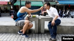 Lin Chinxuan, left, 29, feeds Austin Haung, 32, a dessert in Taipei, Taiwan, Nov. 11, 2018. Lin Chinxuan and Austin Haung are a couple and together they run Hiwow studio photographing LGBTQ couples, who they say mostly come from overseas.