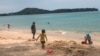 In this March 26, 2020, photo, tourists play on a beach in Phuket, Thailand. 
