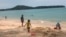 In this March 26, 2020, photo, tourists play on a beach in Phuket, Thailand. 