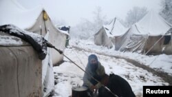 Migrants prepare a breakfast in a snow covered makeshift forest camp near Croatian border in Bihac, Bosnia and Herzegovina December 3, 2019. REUTERS/Dado Ruvic