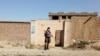 FILE - A Taliban solider stands guard in front of a house neighboring an Islamic State hideout raided by Taliban forces in northern Kabul, Afghanistan Oct. 4, 2021.