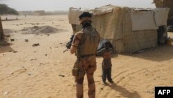Mwanajeshi apita karibu na mtoto wakati anapiga doria nchini Mali. March 25, 2019.