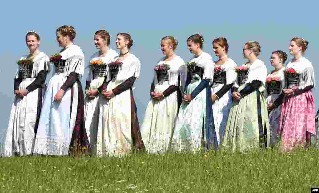 Para perempuan berpakaian tradisional Bavaria ambil bagian dalam prosesi Corpus Christi di desa Wackersberg, Jerman.