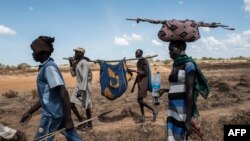 Des proches accompagnent une femme dinka touchée par le choléra dans un hôpital temporaire à Mingkaman, un camp pour personnes déplacées internes (PDI), dans les États des Lacs de l'Est, Soudan du Sud, 26 avril 2017.