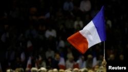 Seorang pendukung mengibarkan bendera Perancis ketika Nicolas Sarkozy, mantan pemimpin partai politik "Les Republicains" dan kandidat pemilihan pendahuluan presiden Perancis menghadiri kampanye di Nimes, Perancis, 18 November 2016.