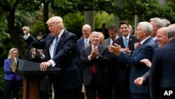 Le président Donald Trump accompagné de membres de la Chambre de représentants tient un discours au jardin rose de la Maison Blanche, à Washington, 4 mai 2017l.