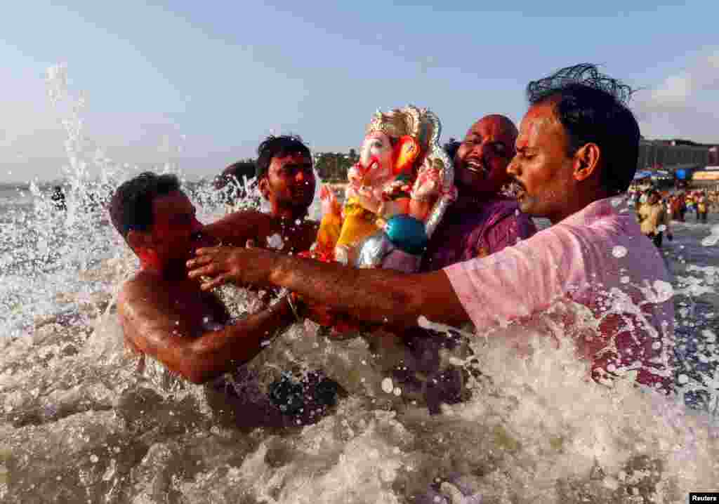 Devotees carry an idol of the Hindu god Ganesh, the deity of prosperity, into the Arabian Sea on the second day of Ganesh Chaturthi festival in in Mumbai, India.