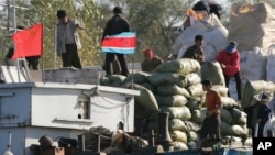 지난 2006년 북-중 접경 도시 단둥에서 북한 무역상들이 중국 선박에 교역품을 싣고 있다.