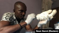 John Amanam works on a prosthetic hand at his company, Immortal Cosmetic Art, in Uyo, Nigeria January 7, 2020. (REUTERS/ Seun Sanni)