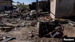 کارگری در یک خانه آسیب دیده از موشک باران روسیه در شهر کراسیلیوکا حفره‌ای را برای رسیدن به لوله گاز حفر می‌کند