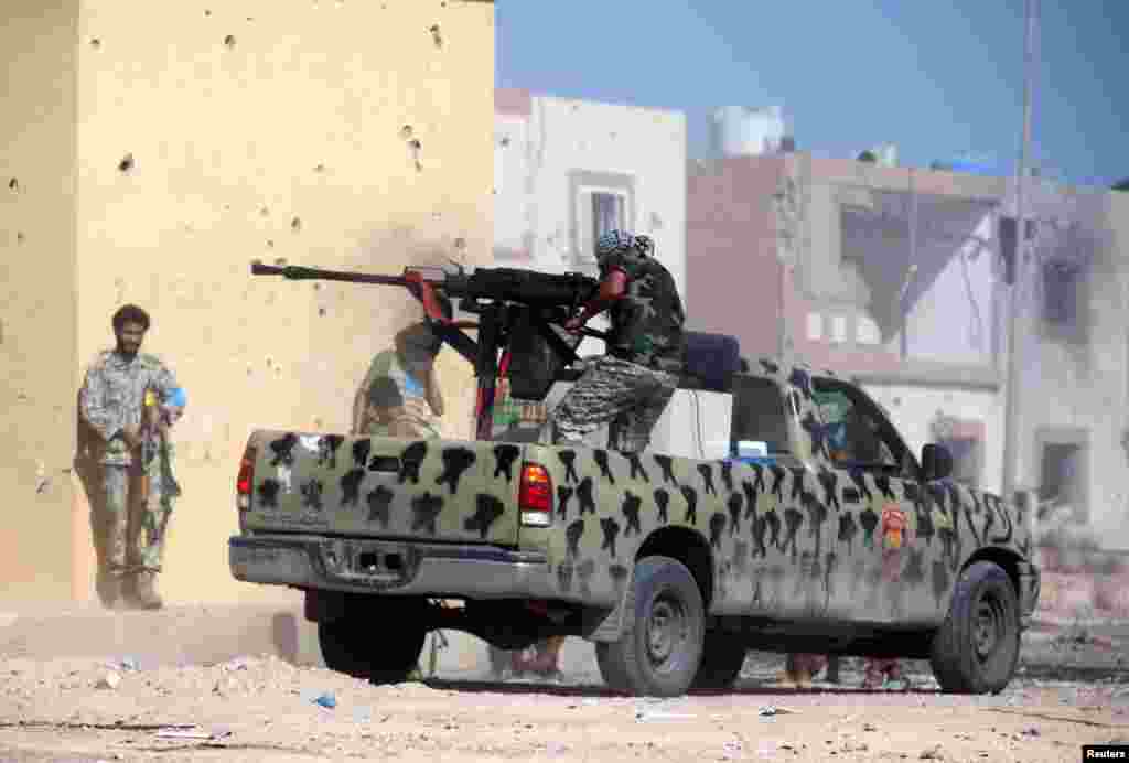 A member of Libyan forces allied with the U.N.-backed government fires a weapon from a pickup truck during a battle with Islamic State militants in Giza Bahreya, in Sirte, Libya.