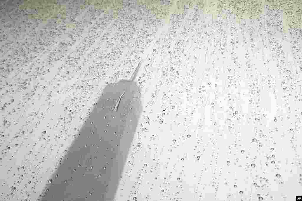 With the One World Trade Center in the background, raindrops form on a window in New York.
