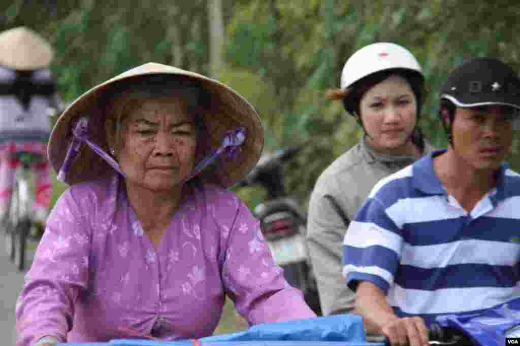A woman bicycles in Tien Giang, Vietnam, September 14, 2012. (D. Schearf/VOA)