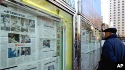 有人在北京街头看报纸（2003年）。中国报纸很多