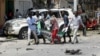 Civilians carry the dead body of a man killed in a car bomb explosion near a hotel in Mogadishu, Somalia, March 28, 2019. 