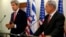 Israeli Prime Minister Benjamin Netanyahu (R) listens as U.S. Secretary of State John Kerry speaks during a news conference following a meeting at Netanyahu's office in Jerusalem, Dec. 5, 2013. 