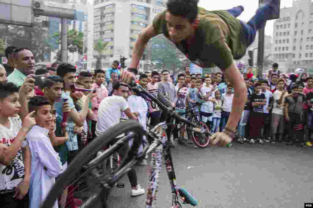 Seorang remaja melakukan atraksi di lapangan Mostafa Mahmoud usai shalat Idul Fitri di Kairo, Mesir. (H. Elrasam/VOA)