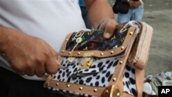 在菲律宾马尼拉政府工作人员在处理打击假冒产品行动中缴获的商品，割开假冒的路易威登皮包