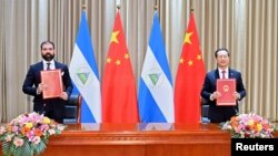 中国外交部副部长马朝旭（右）和尼加拉瓜代表在天津签署联合公报。（2021年12月10日）