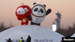 工人在北京冬奥会场馆树起冬奥会吉祥物冰墩墩和雪容融。（2022年1月11日）