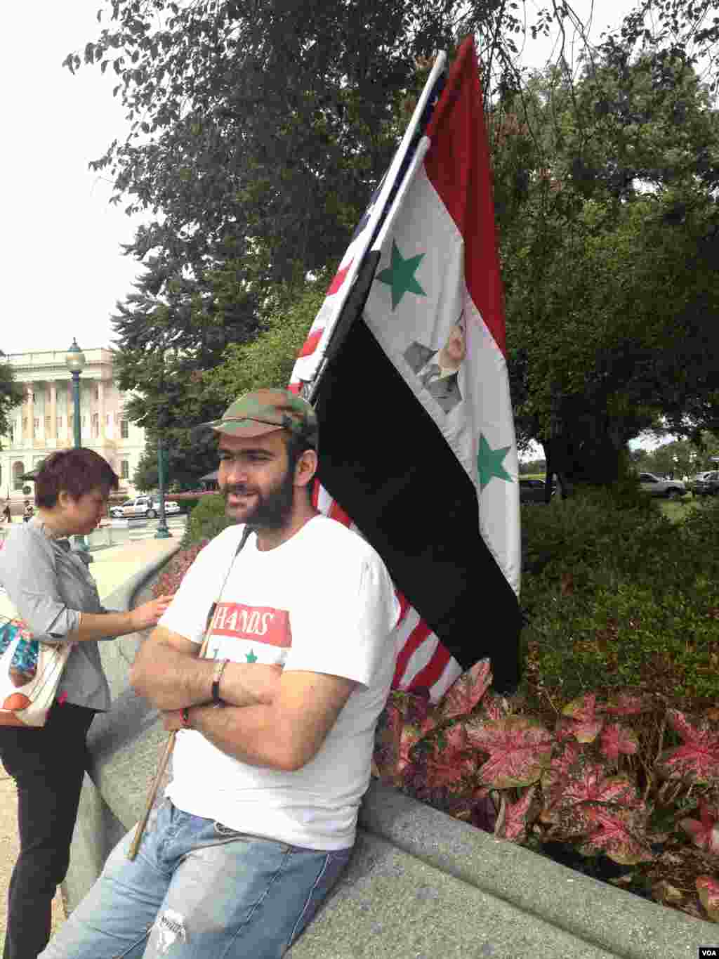 抗议人士扛着叙利亚的国旗，背后是美国之音记者杨晨在现场。(美国之音 龚小夏拍摄)